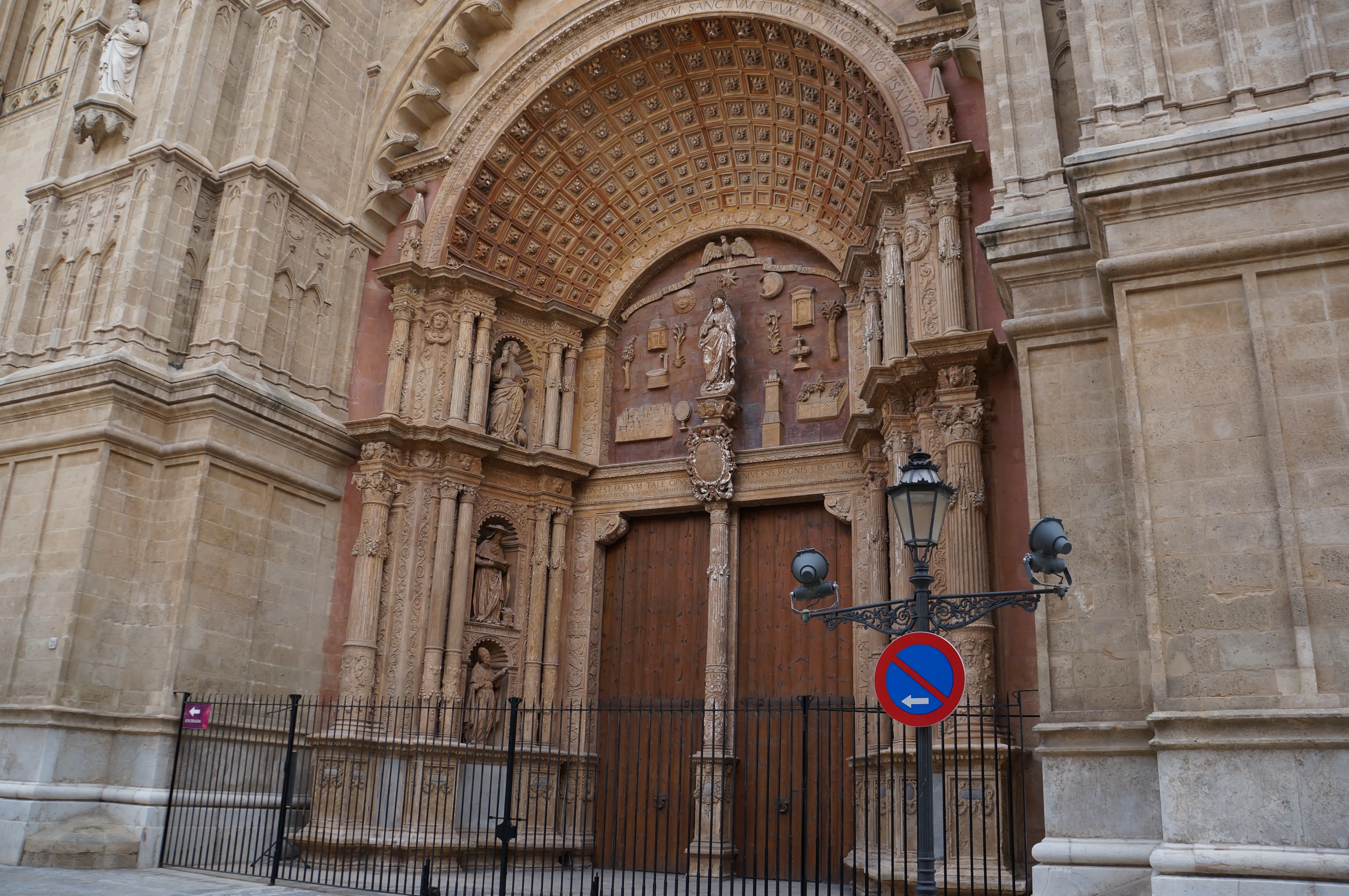 Das reich verzierte Hauptportal der Kathedrale La Seu in Palma mit Figurennischen, Reliefs und schmiedeeiserner Laterne davor.
