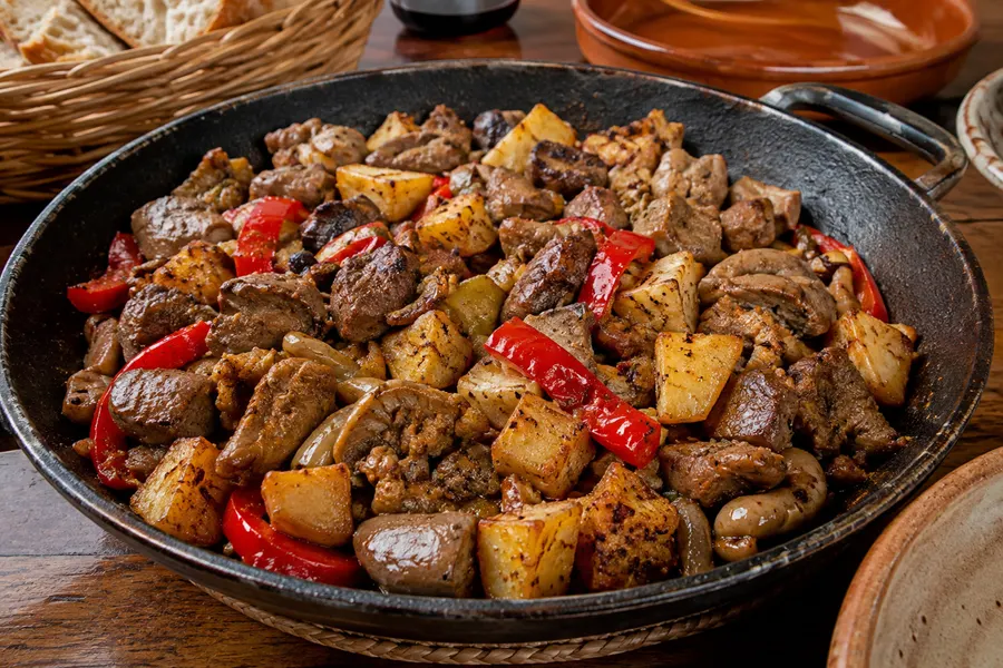 Frit mallorquí — Innereien, Kartoffeln, Paprika, Fenchel, in der Pfanne gebraten. (mit künstlicher Intelligenz erzeugte Abbildung)