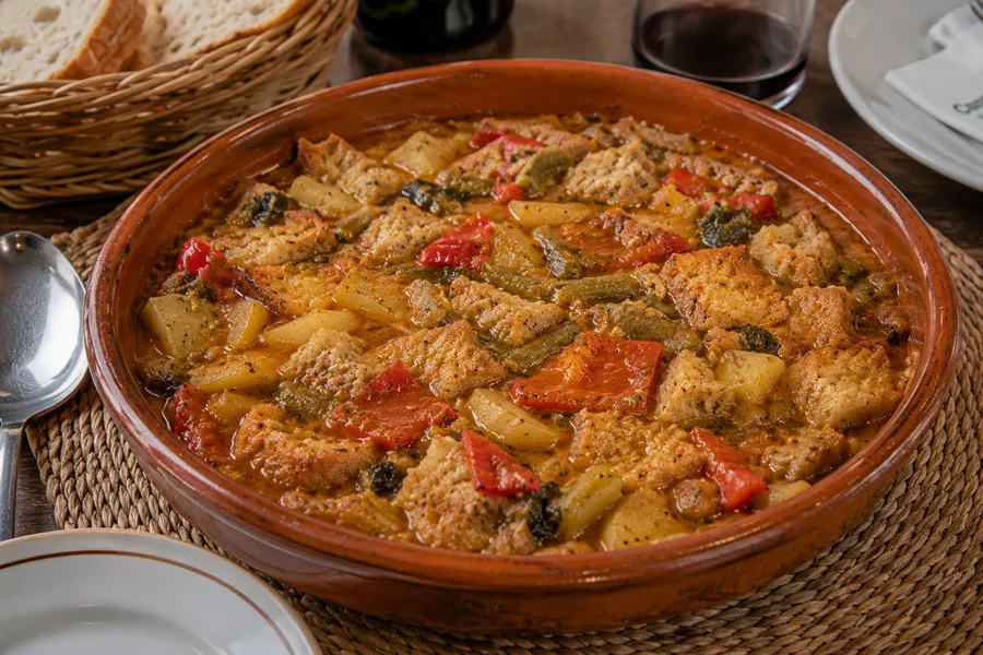 Sopes mallorquines — Trotz des Namens keine Suppe: Gemüse mit dünn geschnittenem Brot aufgesogen. (mit künstlicher Intelligenz erzeugte Abbildung)