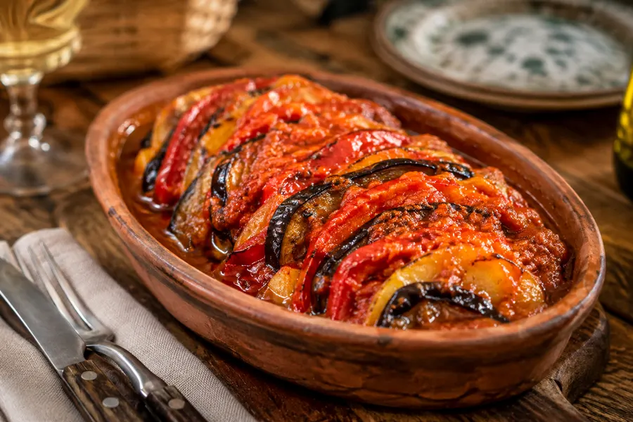 Tumbet — Geschichtetes Gemüse — Kartoffel, Aubergine, Paprika — mit Tomatensauce. (mit künstlicher Intelligenz erzeugte Abbildung)
