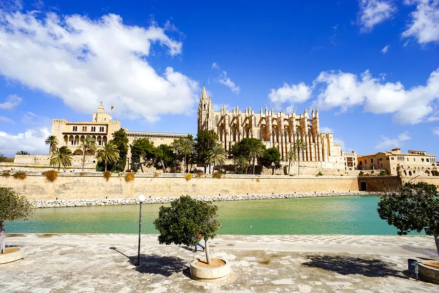 Die Kathedrale von Palma und der Palau de l'Almudaina über der Stadtmauer, davor das grüne Wasserbecken des Parc de la Mar.
