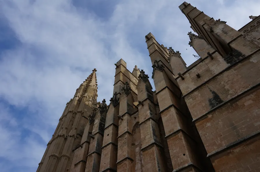 Untersicht auf das Strebewerk der Kathedrale von Palma: mächtige Strebepfeiler aus honigfarbenem Sandstein ragen gegen den Himmel.