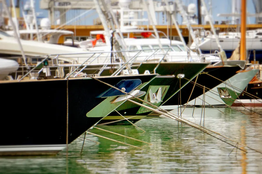 Bug einer großen Segelyacht mit gespannten Vorstagen im Hafen von Palma, daneben weitere Masten.
