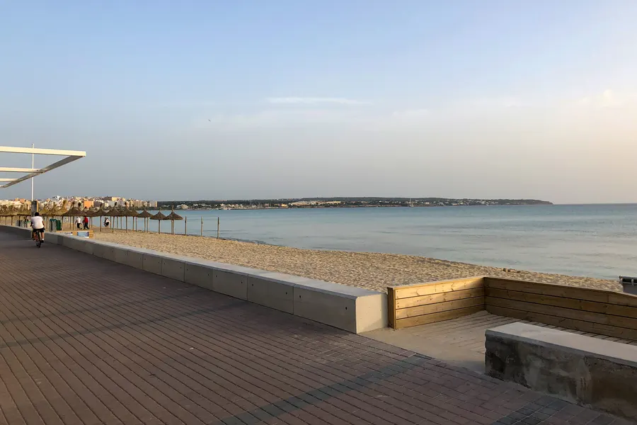 Zwei Angler als Silhouetten am Ufer der Platja de Palma vor der goldenen Abendsonne über der Bucht.
