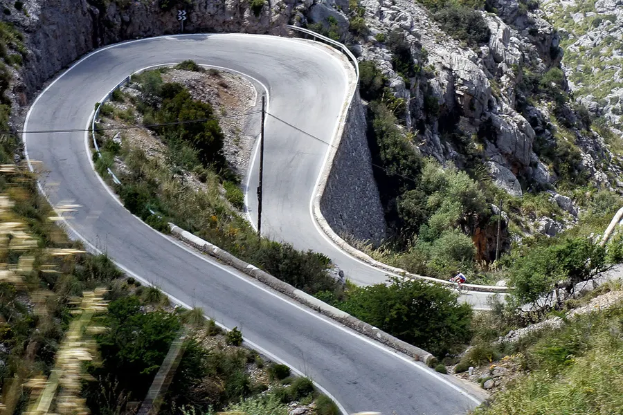 Enge Haarnadelkurve der Serpentinenstraße nach Sa Calobra, von oben gesehen, zwischen kahlen Felsflanken.