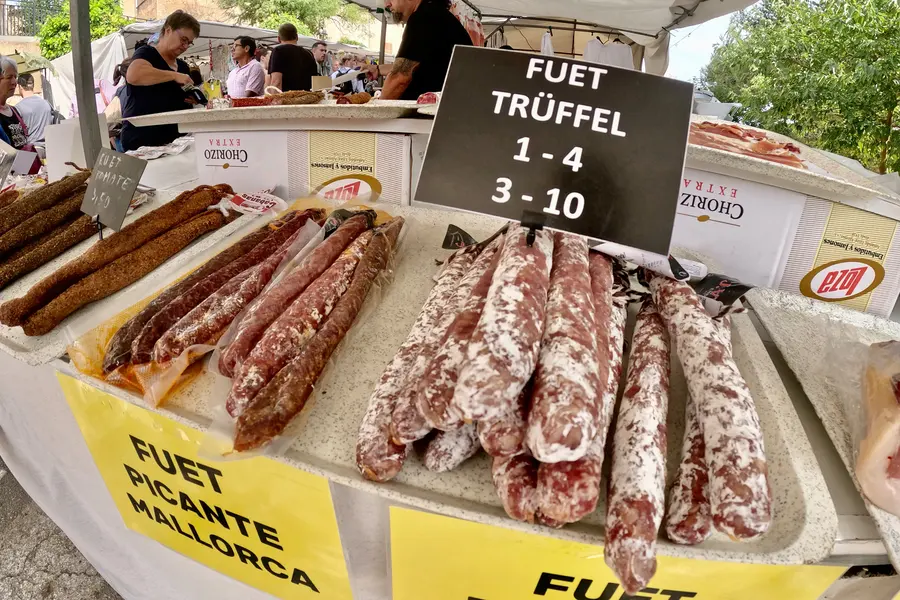 Ausgelegte Fuet-Würste mit einem Schild, auf dem Trüffel-Fuet und Preise stehen.